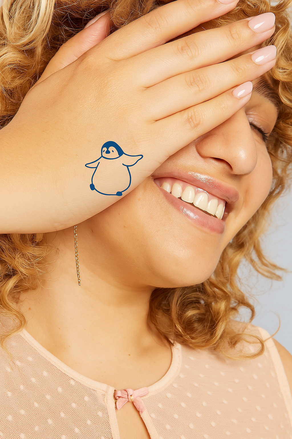 Model ilustrativ cu pinguin, sub formă de tatuaj temporar